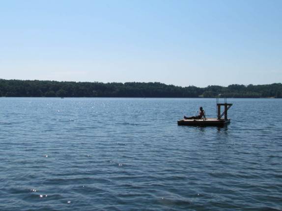 Tomando sol na pequena plataforma flutuante no lago em Lakeville, estado de Connecticut, nos Estados Unidos